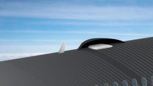 A close-up render of the fuselage roof of a business jet in flight, showing a fin and low-profile white satellite antenna housed beneath a aerodynamic fairing, with blue sky in the background.