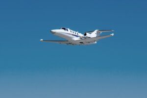 Cessna Citation M2 Gen3 light jet climbing through clear blue sky