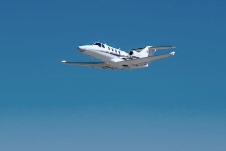 Cessna Citation M2 Gen3 light jet climbing through clear blue sky