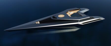 Aerial render of the Wotan concept speed yacht by Agnès Guiu Design, viewed from above on a dark, calm sea. The vessel features an extreme arrow-shaped hull in deep navy blue with white accent trim lines running along its edges. A helipad and open deck area with warm timber decking are visible amidships