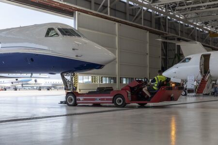 Gulfstream announces new Singapore customer support facility 14:52Claude responded: Ground crew tows private jet out of aviation hangar with tug.Ground crew tows private jet out of aviation hangar with tug
