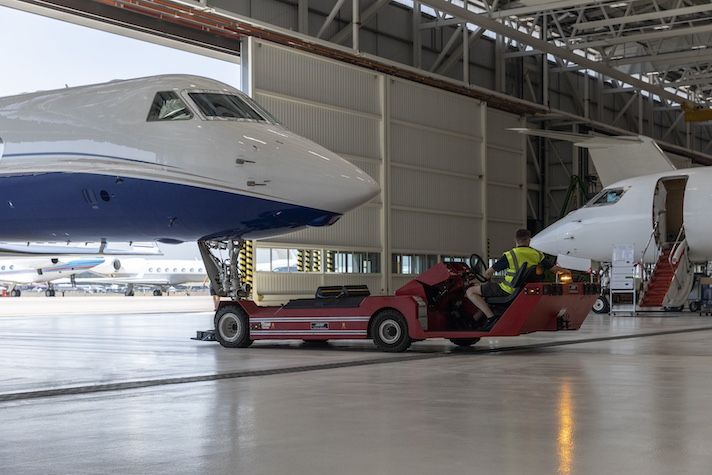 Gulfstream announces new Singapore customer support facility 14:52Claude responded: Ground crew tows private jet out of aviation hangar with tug.Ground crew tows private jet out of aviation hangar with tug