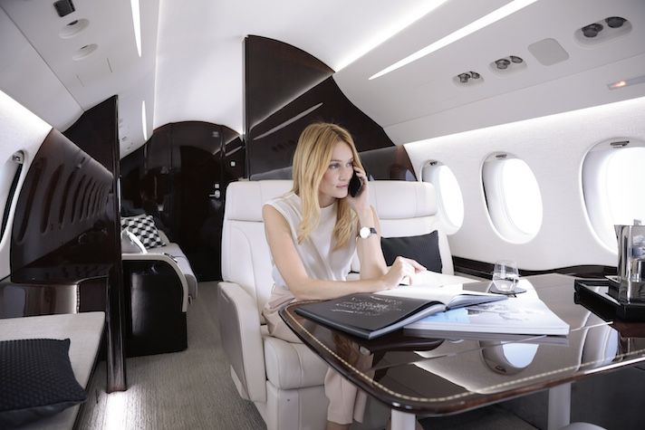 Woman using a mobile phone onboard a private jet