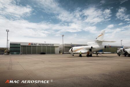 3C inspection completed by AMAC Aerospace Turkey on Falcon 900EX EASy A business jet on a concrete apron next to a fuel truck, with ground crew nearby and an AMAC Aerospace hangar visible in the background.