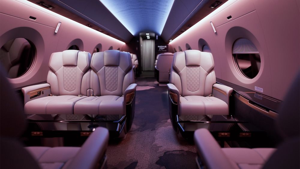 Aircraft aft cabin with club-four and club-two seating under pink and blue mood lighting, with oval windows along both sides.