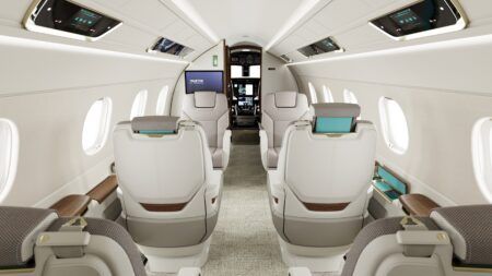 Interior of the Embraer Praetor 500E cabin looking towards the cockpit, with facing club seats