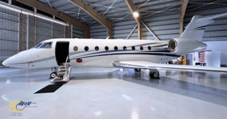 A white Gulfstream G280 business jet parked inside a hangar with its forward airstair door open.