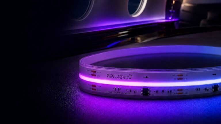 Close-up of Spectrum Networks’ Aura LED strip lighting glowing purple and blue on a business jet cabin surface