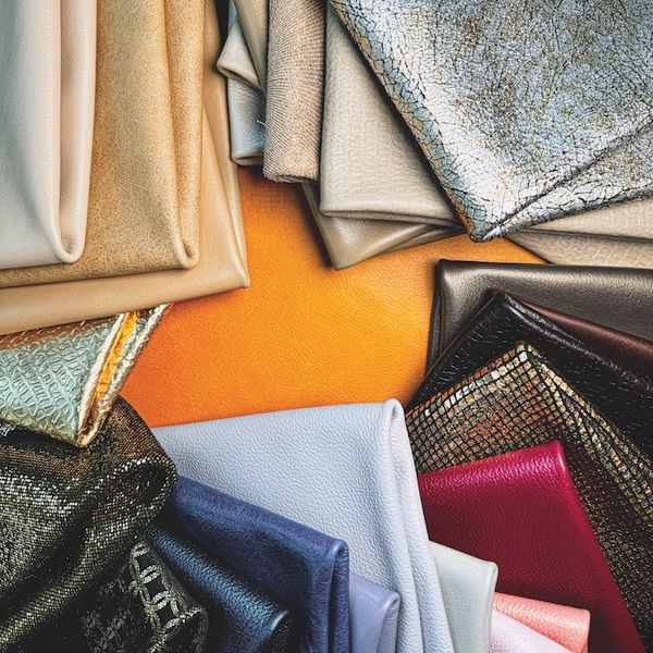 An assortment of folded leather swatches in gold, silver, navy, red and patterned finishes from Townsend Leather's Cleopatra collection.