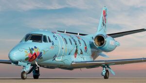 Duncan Aviation’s Citation Excel N1KD on airport ramp, light blue livery with flowers and birds