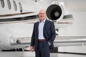 Brian Rohloff standing in a hangar in front of a business jet