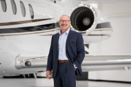 Brian Rohloff standing in a hangar in front of a business jet