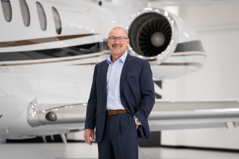 Brian Rohloff standing in a hangar in front of a business jet