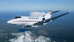 Hawker 900 business jet in flight over mountainous terrain