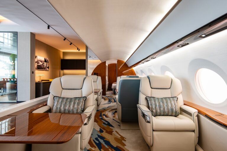 G700 fuselage mockup open on one side to wider lounge, with cream leather aircraft seats, wood panelling and carpet in tones of cream, blue and tan