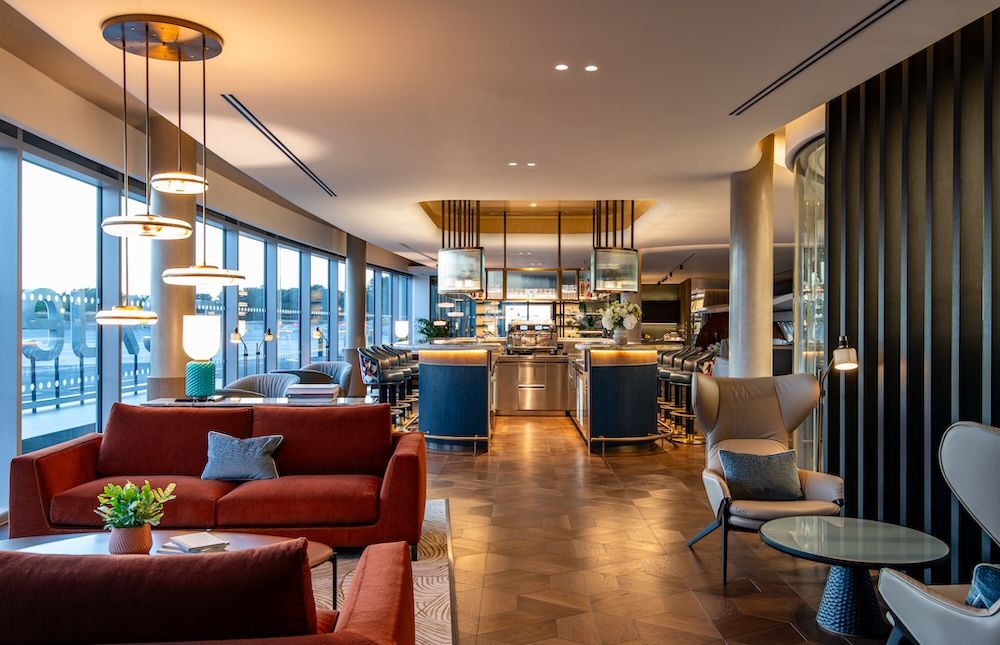 Lounge with red sofas, central bar and floor-to-ceiling windows