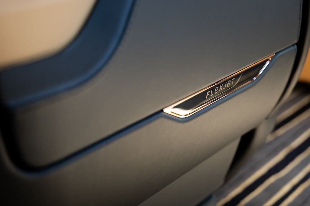 Close-up of side of seat, with gold tab displaying Flexjet logo