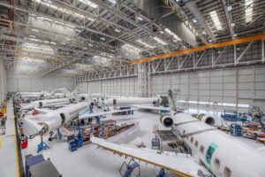 Interior of an aircraft MRO hangar showing several business jets undergoing work