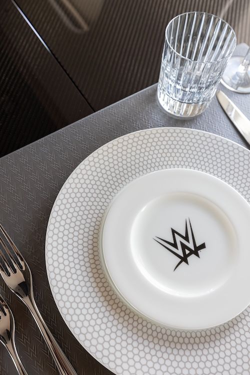 Monogrammed china plate, crystal glass and cutlery on board