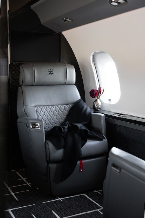 Grey leather seat with monogrammed headrest and blanket, on private aircraft