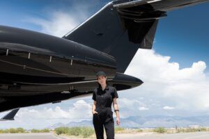 Sarah Mespelt Larranaga standing beside the tail of a private jet