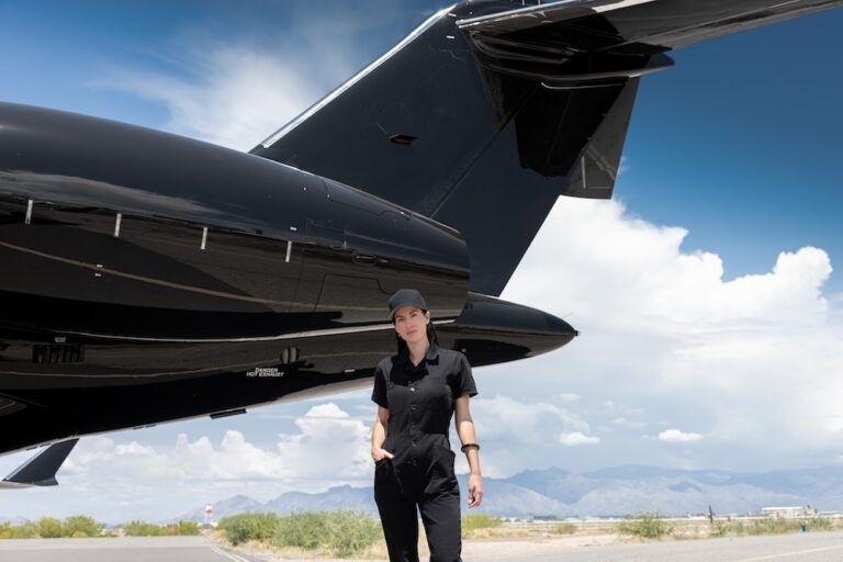 Sarah Mespelt Larranaga standing beside the tail of a private jet