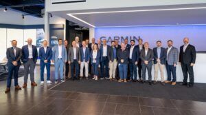 Group of executives posing in front of Garmin sign
