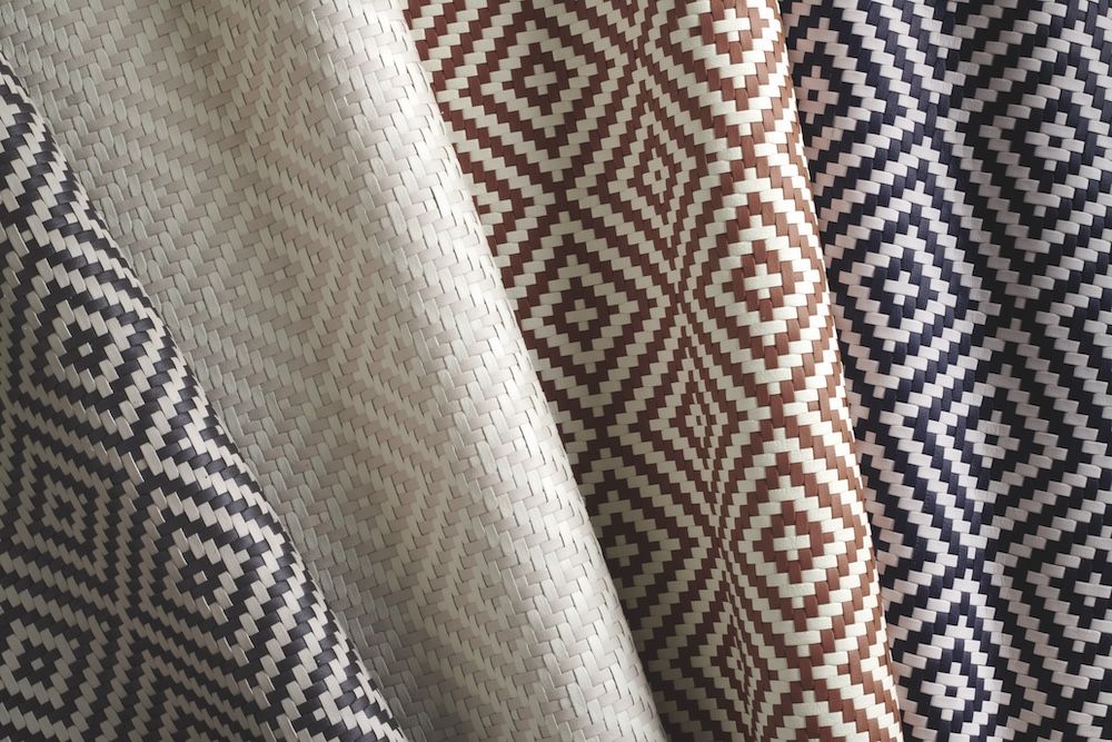 Four draped woven leather samples in diamond patterns in black and white, beige and white, tan and white, and blue and white