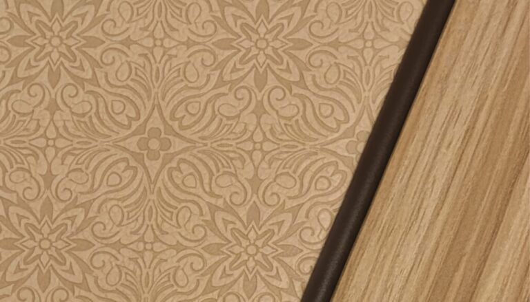 FEATURE: Natalie Rodríguez shares a unique cabinetry design Close-up of BBJ cabinetry showing a textured leather insert with an embossed floral pattern, edged in dark leather welt cord and framed by satin-finished wood veneer